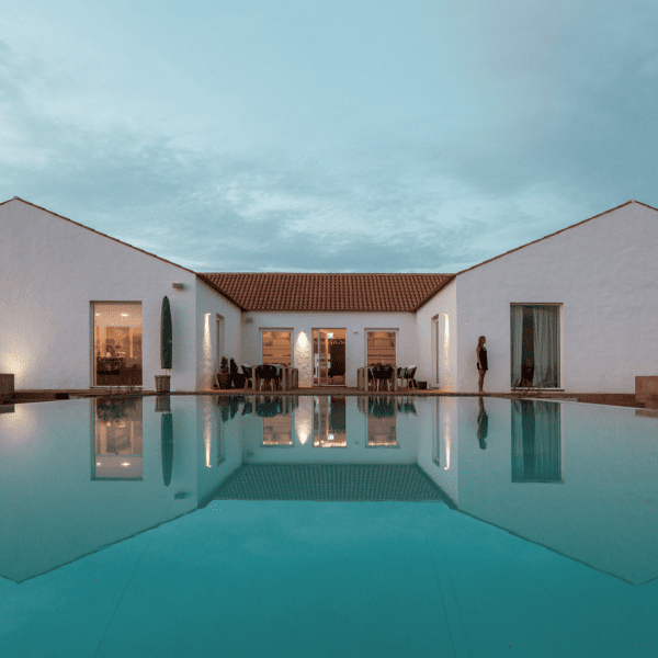 Vista panorâmica da Herdade da Malhadinha Nova, uma propriedade pitoresca em Portugal. A paisagem exibe vinhas ondulantes, olivais e a beleza tranquila da região do Alentejo. A mistura harmoniosa da natureza e da arquitetura da propriedade é evidente, criando uma atmosfera serena e convidativa. Uma viagem visual que capta a essência deste destino idílico, convidando os hóspedes a saborear a beleza e a tranquilidade da Herdade da Malhadinha Nova